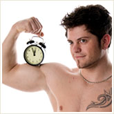 Man Holding an Alarm Clock on His Bicep